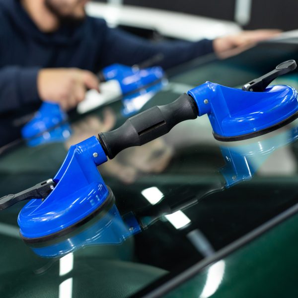 Glass of the car is a close-up in the room, removed with the help of professional suction cups. The process of car repair